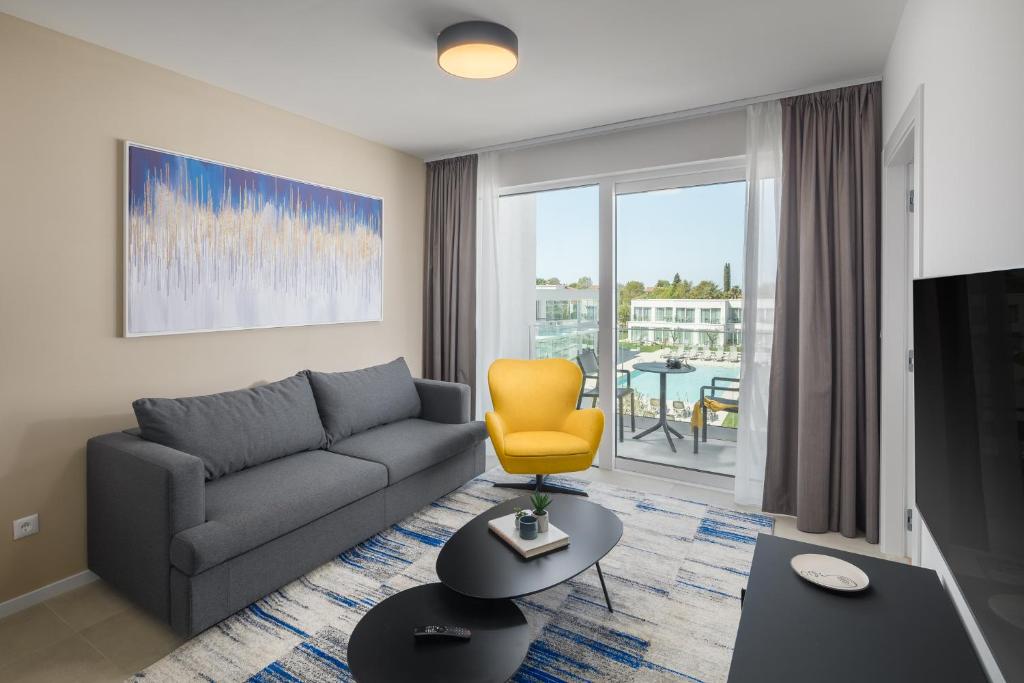 a living room with a couch and a yellow chair at Maj Luxury Residence in Poreč