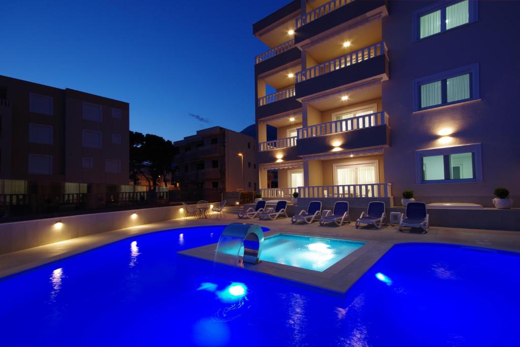a swimming pool in front of a building at night at Stella Maris in Promajna
