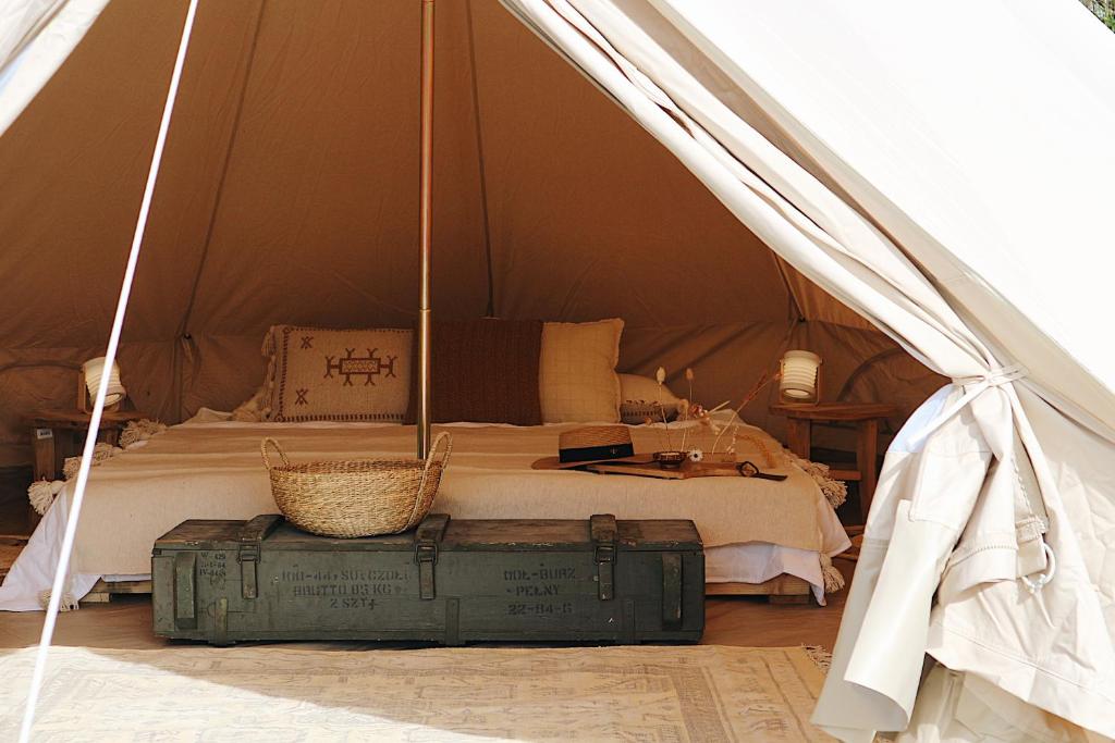 sypialnia z łóżkiem i walizką w namiocie w obiekcie Bell Tent Parc Bûten Jubbega w mieście Jubbega-Schurega