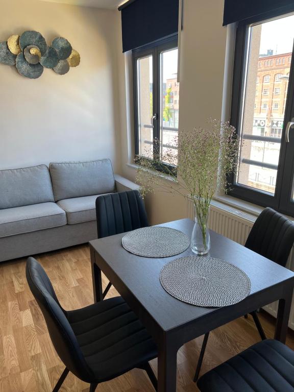 uma sala de estar com uma mesa e cadeiras e um sofá em Cosy appartement with canal view em Bruxelas