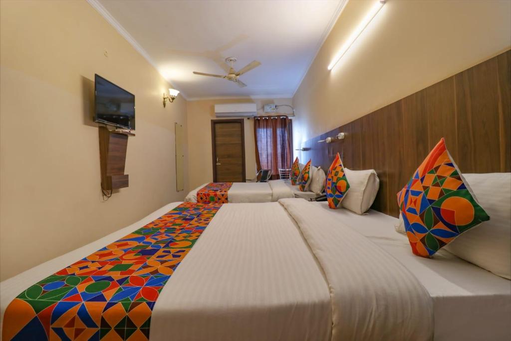 - une chambre avec un grand lit et des oreillers colorés dans l'établissement Hotel Golden Sunrise inn, à Amritsar