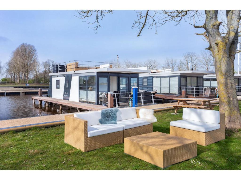 una casa con dos sofás y una mesa y un barco en Unique boat in Offingawier with private garden, en Offingawier