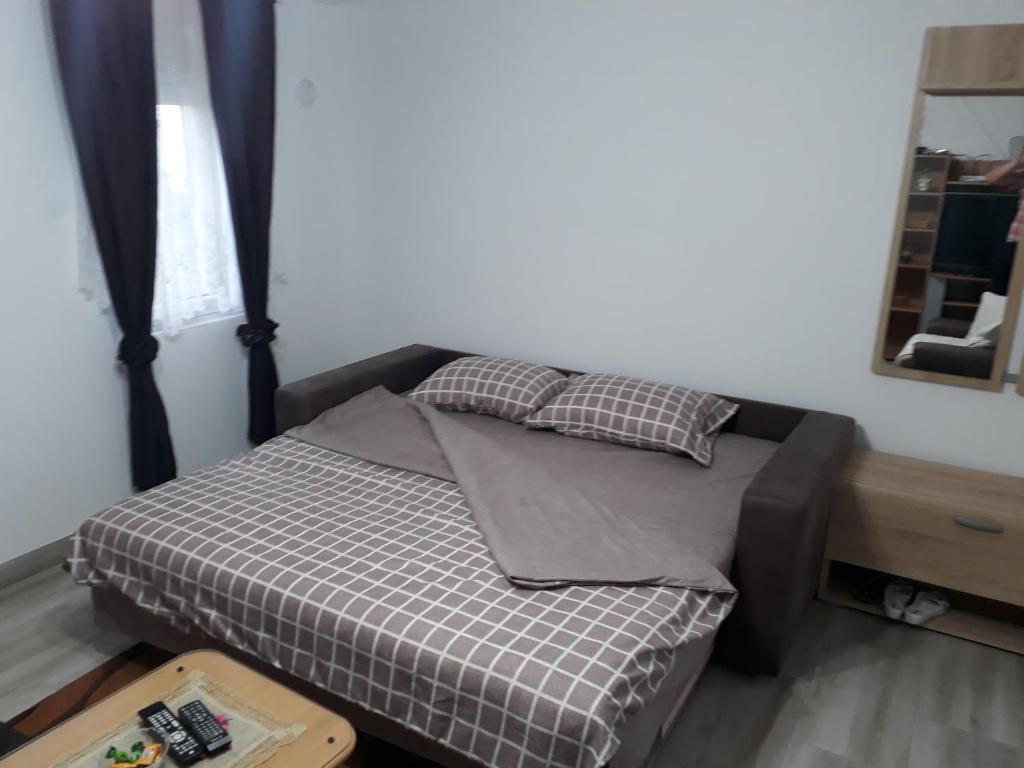 バニャ・コヴィリャチャにあるLazarev konak apartman kucicaのベッド1台(枕2つ、鏡付)