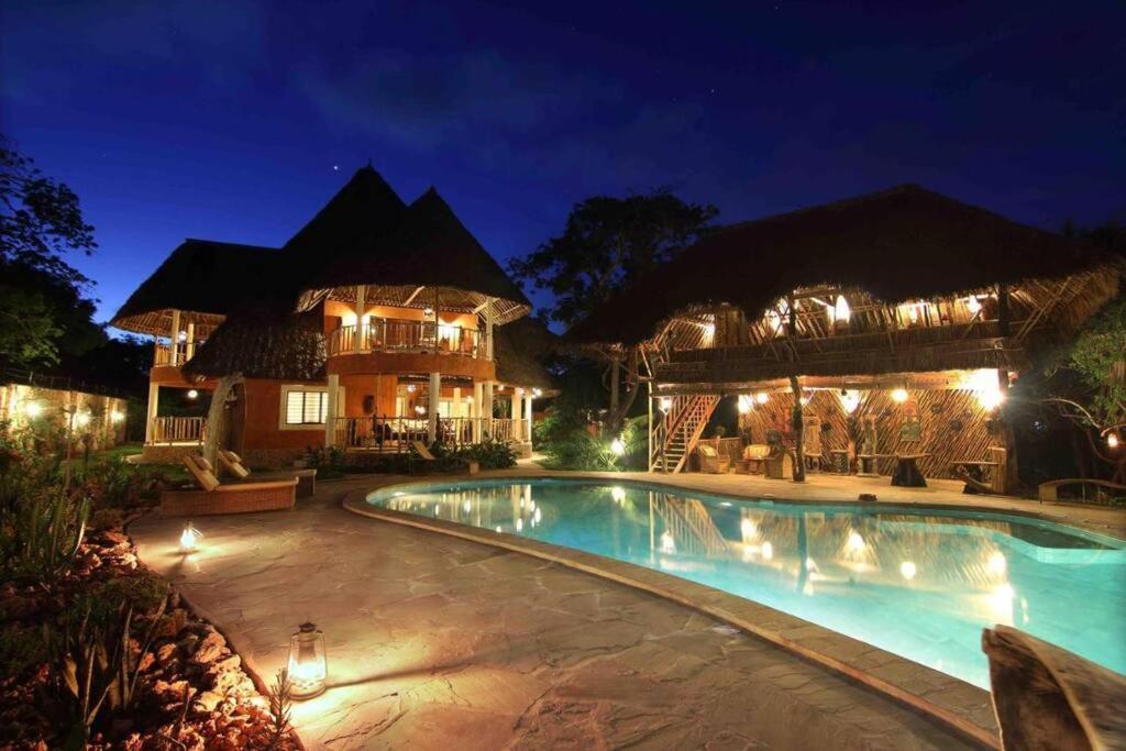 ein Resort mit Pool in der Nacht in der Unterkunft Villa Ndoto in Diani Beach