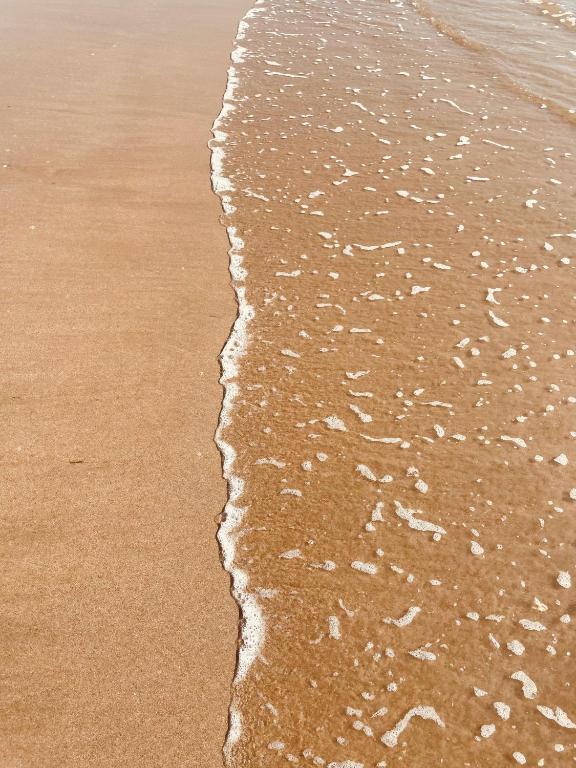 a close up of the sand and water on the beach at Hôtel L'Albatros in Saint-Trojan-les-Bains