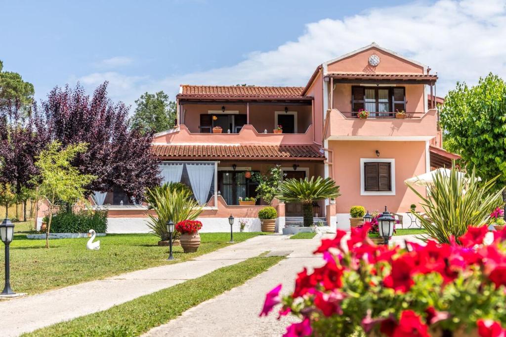 a pink house with flowers in front of it at Areti Apartment in Áfra