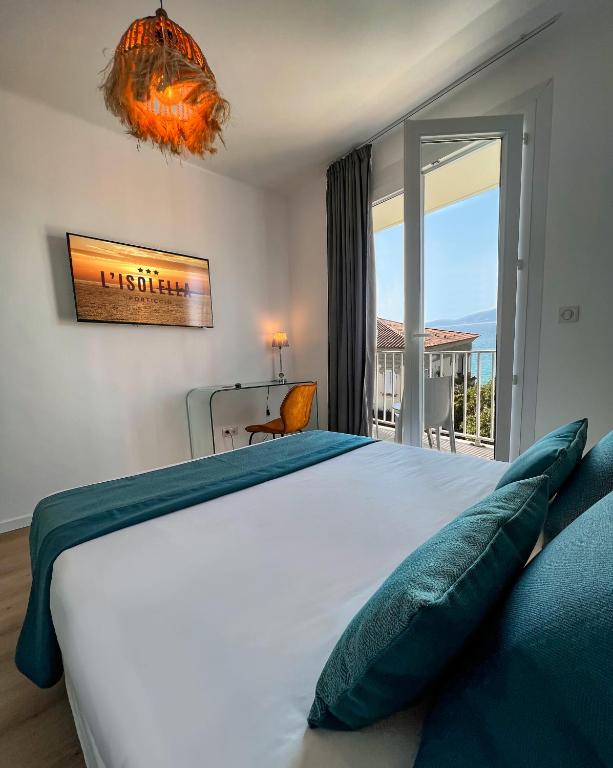 a bedroom with a large bed and a balcony at Hotel l'Isolella in Porticcio