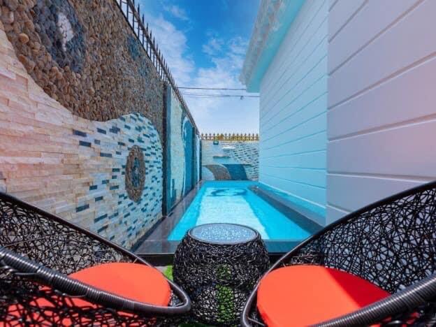 - une piscine avec 2 chaises et une table dans l'établissement Pallas Villa, à Vung Tau