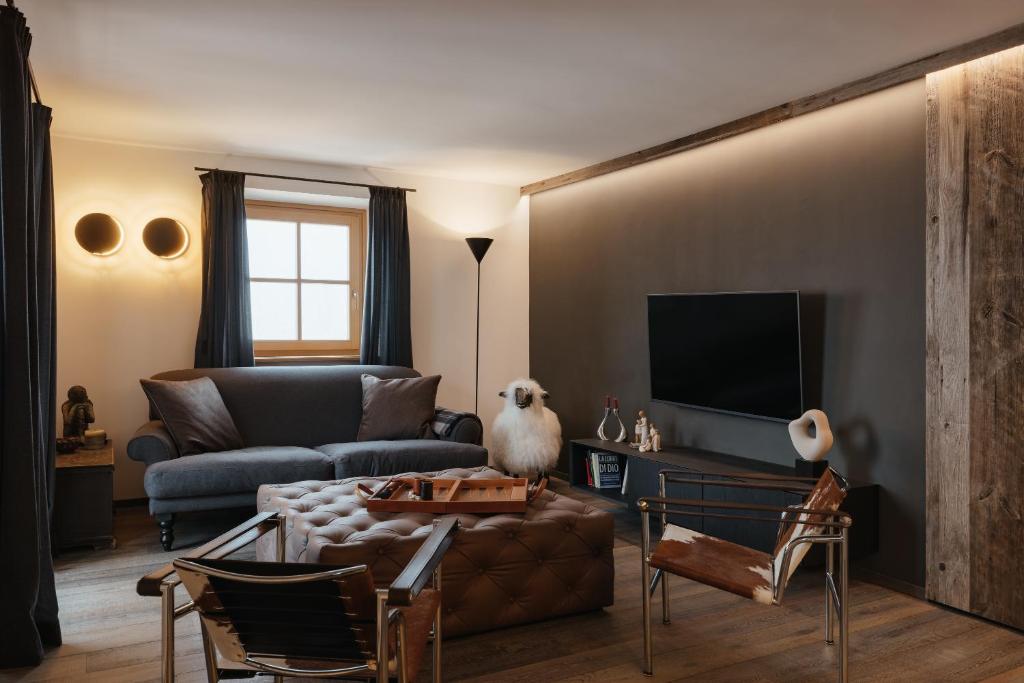 a living room with a couch and a tv at The Grey Lodge at Bosco Verde in San Cassiano