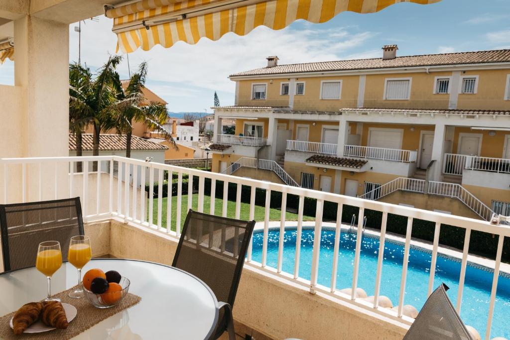 balcón con mesa y sillas y piscina en Townhouse with terraces and communal pool, en Gandía