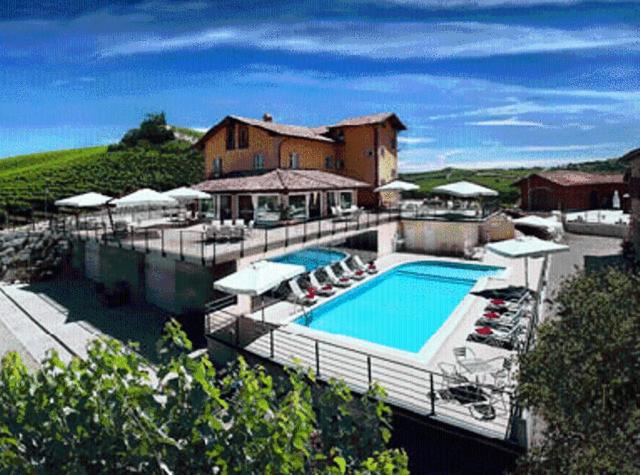 un bâtiment avec une piscine et une maison dans l'établissement Mongalletto, à Castellinaldo