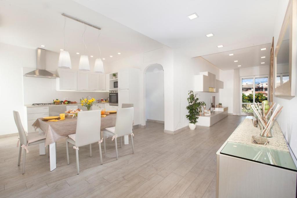 a white kitchen and dining room with a table and chairs at Estate4home - Casa Rosangela in Sorrento