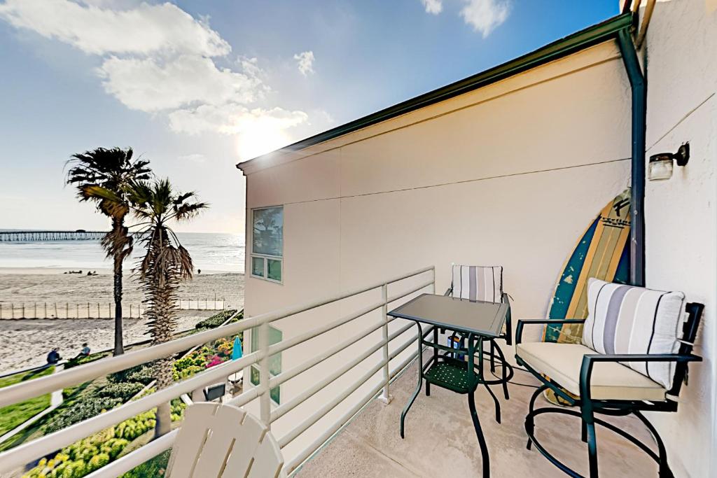 Un balcón con mesa y sillas y la playa. en Imperial Beach Club Unit 303 Oceanfront condo, direct beach access, pool, hot tub, & private balcony, en Imperial Beach