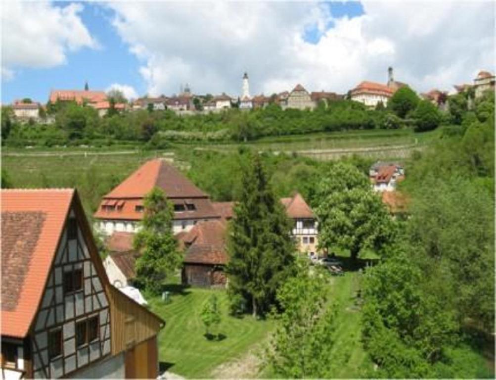 widok na wioskę z domami i drzewami w obiekcie HERRNMÜHLE - Pension & Ferienwohnungen w mieście Rothenburg ob der Tauber