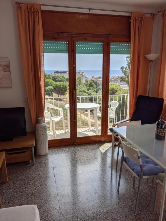 a living room with a table and chairs and a balcony at Apartamentos Juan Jose in Lloret de Mar