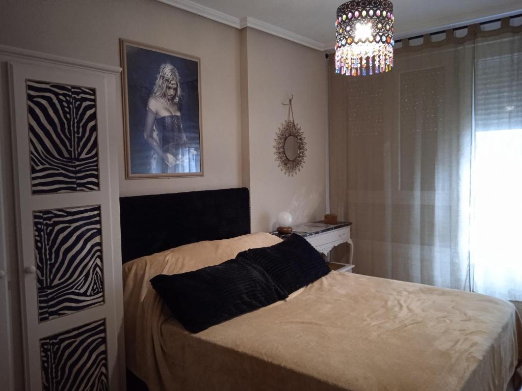 a bedroom with a bed and a chandelier at Precioso apartamento en Santander cerca de todo in Santander