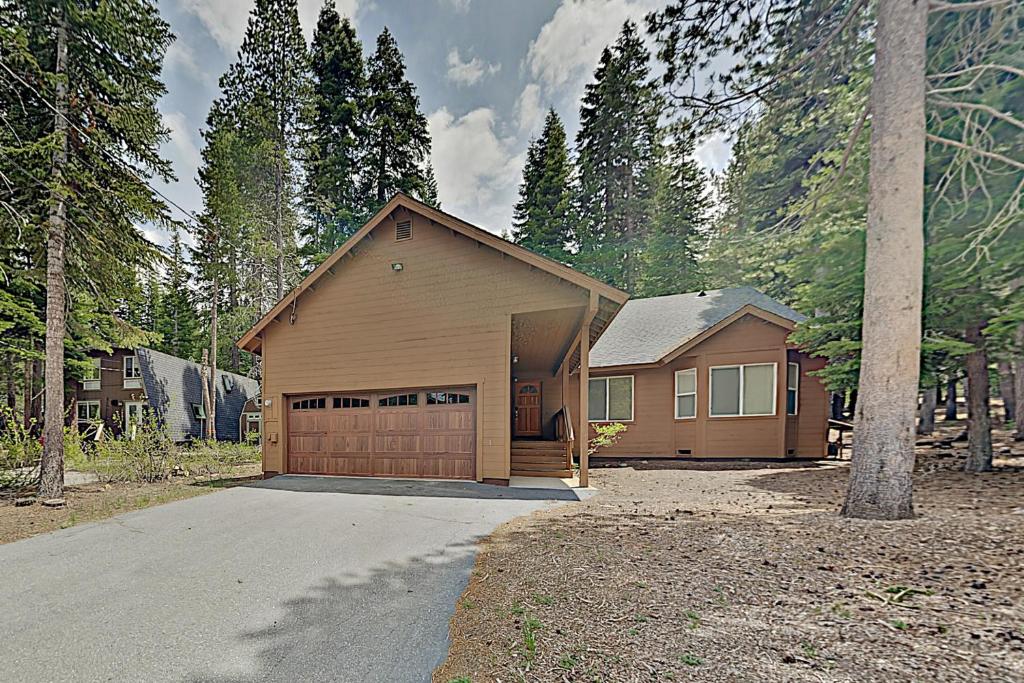 een bruin huis met een garage in het bos bij Northwoods Escape in Truckee