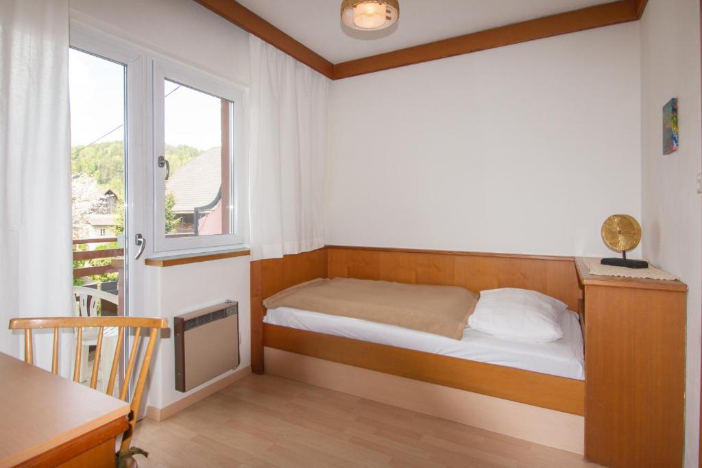 Gästehaus Schreier في Ledenitzen: غرفة نوم صغيرة بها سرير ونافذة
