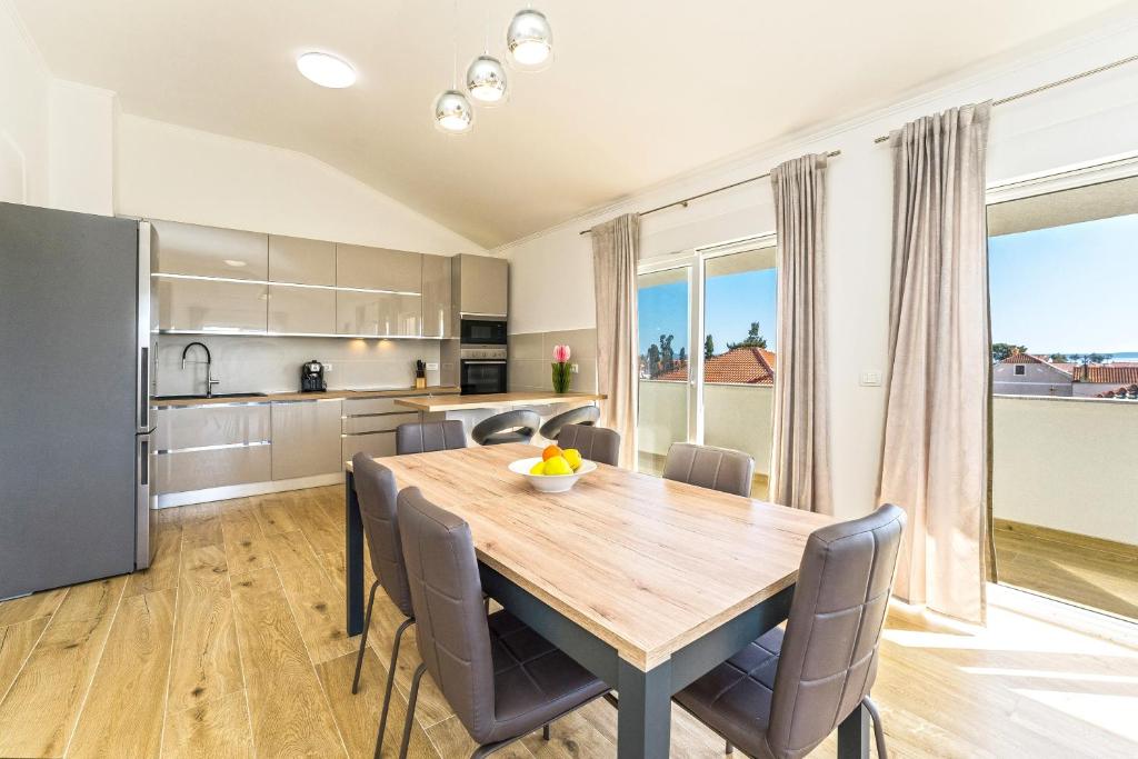 Il comprend une cuisine et une salle à manger avec une table et des chaises en bois. dans l'établissement VILLA BIANCA - villa with a swimming pool, à Privlaka