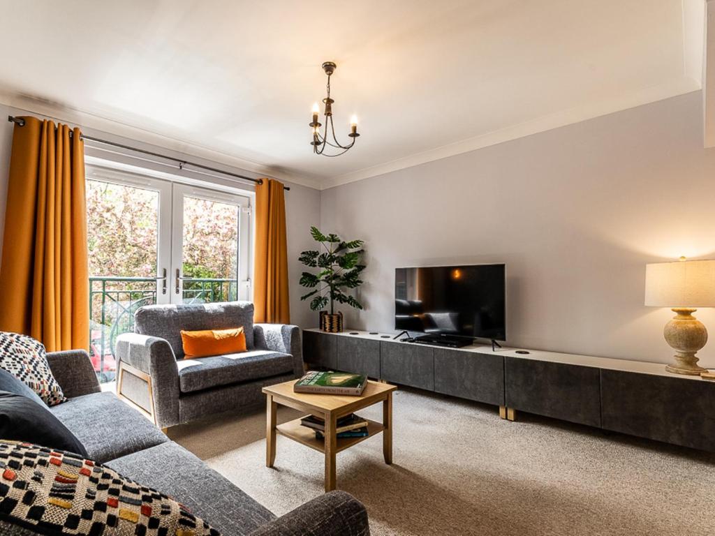 a living room with a couch and a tv at Pass the Keys Stylish holiday townhouse by the Quay with parking in Exeter