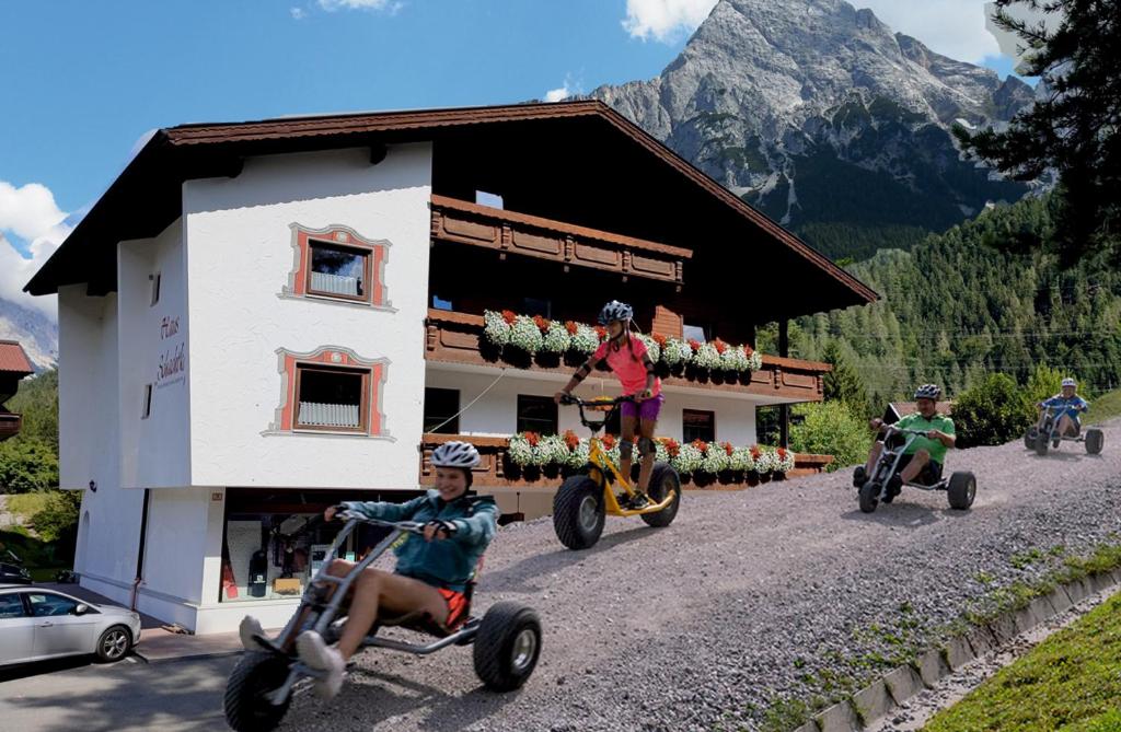 a group of children riding onicycles in front of a building at Zugspitz-Arena Fewo Haus Schachtkopf in Biberwier