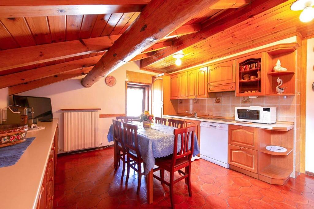 a kitchen with a table with chairs and a microwave at Appartamenti Valeria 1 in Livigno
