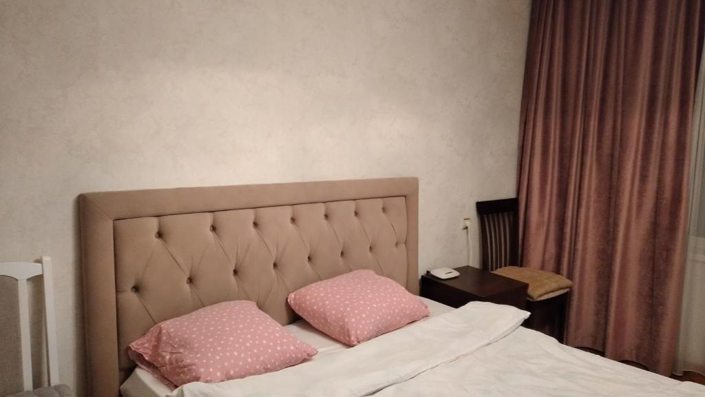 een bed met twee roze kussens erop bij Apartment on Dacia in Chişinău