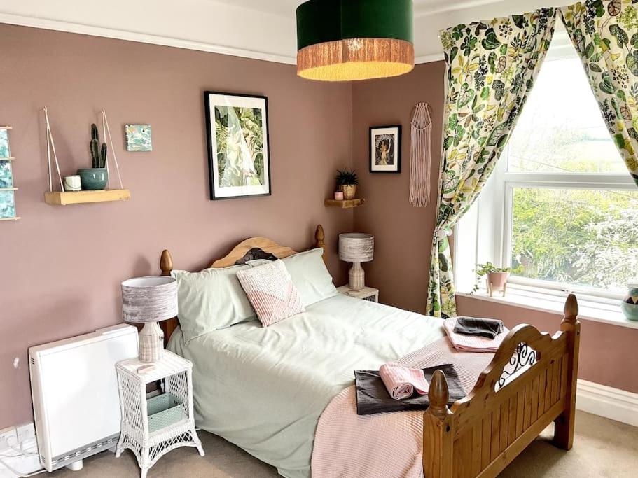 um quarto com uma cama e uma janela em Unique 2-bedroom Coastal Town Retreat em Kingsbridge