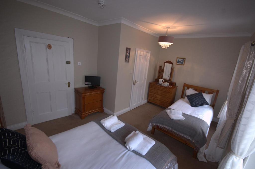 a living room with two beds and a television at Lizzys Little Kitchen Town Accommodation in Listowel