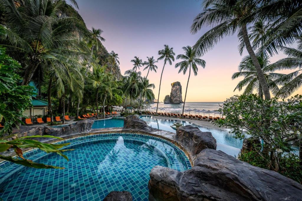 a beach with palm trees and palm trees at Centara Grand Beach Resort & Villas Krabi - SHA Plus in Ao Nang Beach