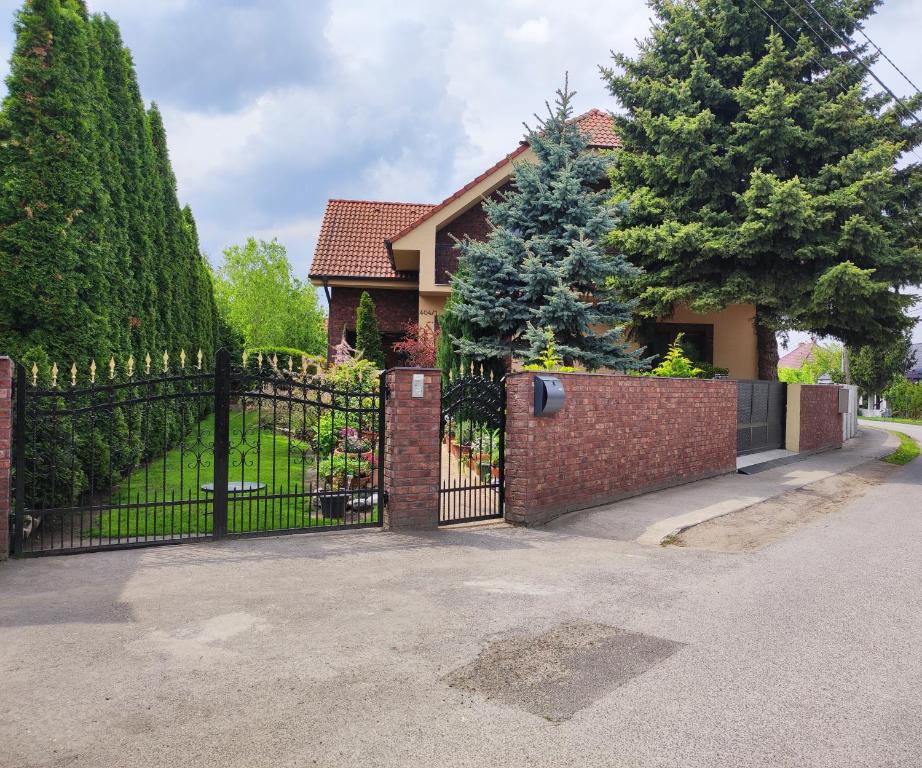 a house with a wrought iron gate and a driveway at Ubytovňa Ivona in Hroboňovo