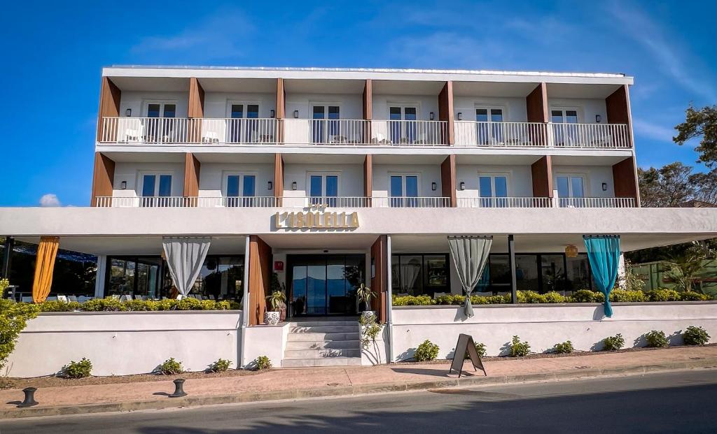 a large white building on the side of the street at Hotel l'Isolella in Porticcio