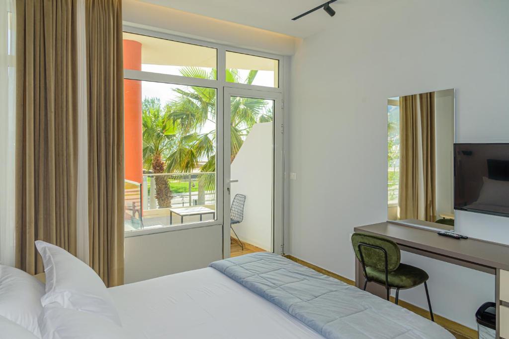 una camera con letto e scrivania con computer di Palm Side Hotel a Vlorë