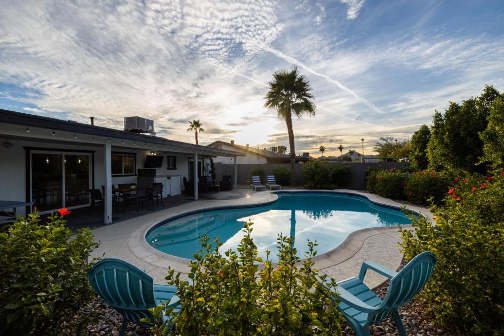een zwembad met stoelen en een huis bij Phoenix Winchcomb home in Phoenix
