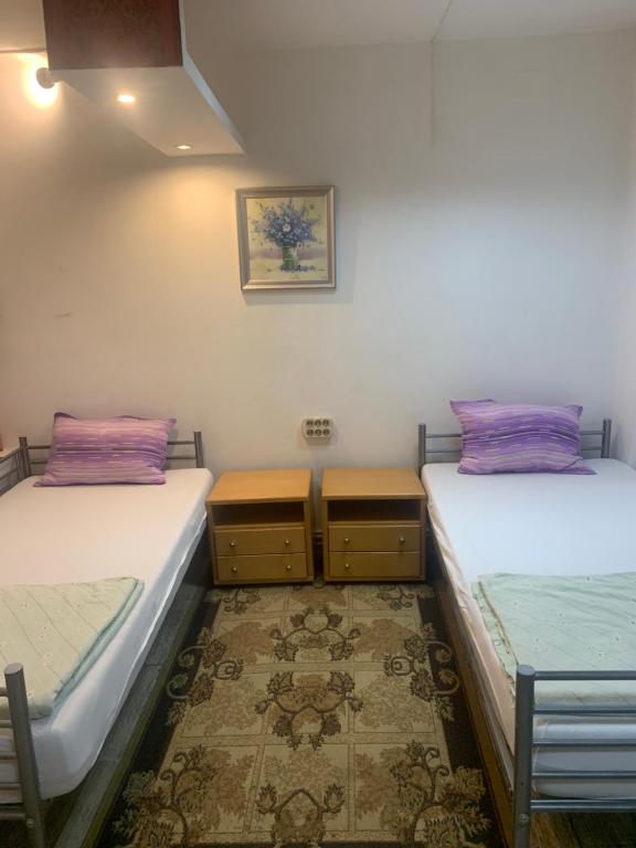 a room with two beds and two night stands at Casa Roz in Cluj-Napoca