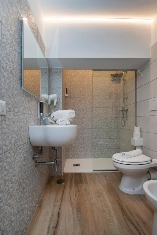 a bathroom with a sink and a toilet and a mirror at Gu Hotel in Guidonia