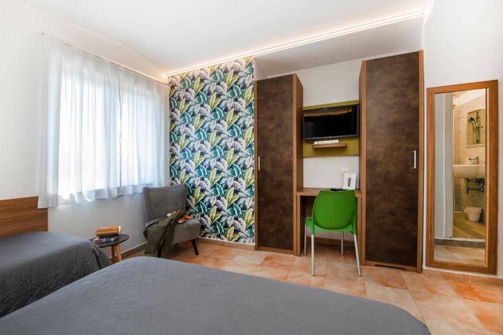 a hotel room with a bed and a green chair at Gu Hotel in Guidonia