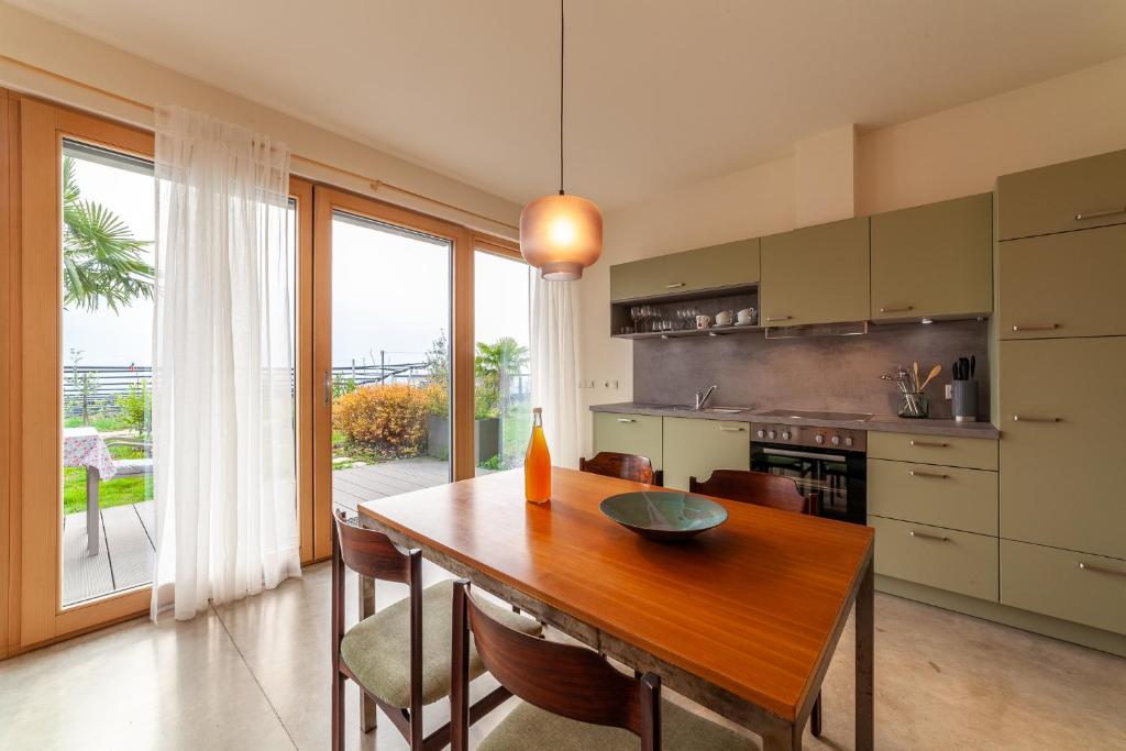 uma cozinha com uma mesa de madeira com cadeiras e uma grande janela em Apartment Vitus em Cermes
