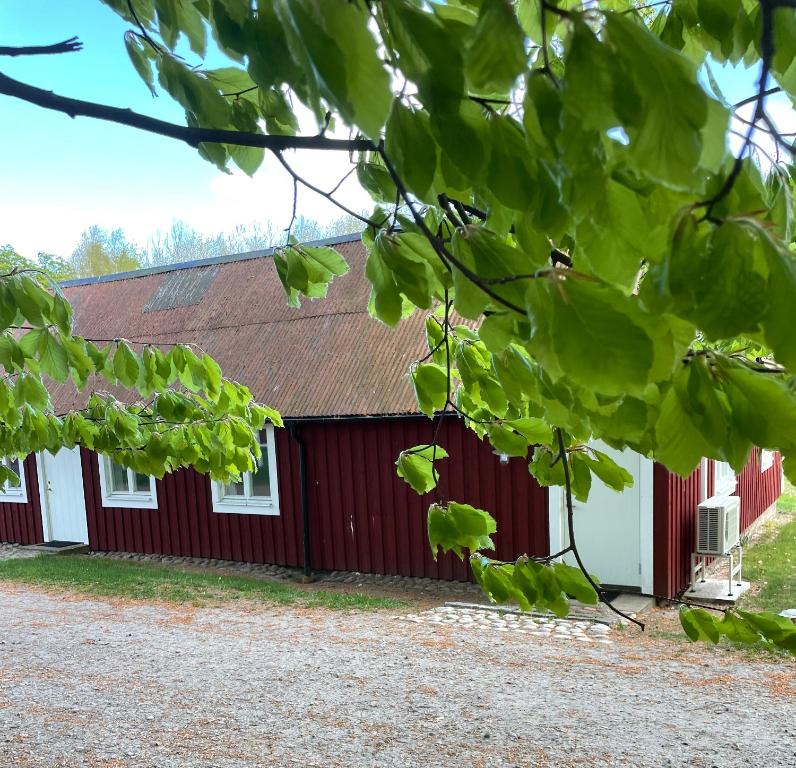 um edifício vermelho e branco com um telhado vermelho em Grindhuset em Skottorp