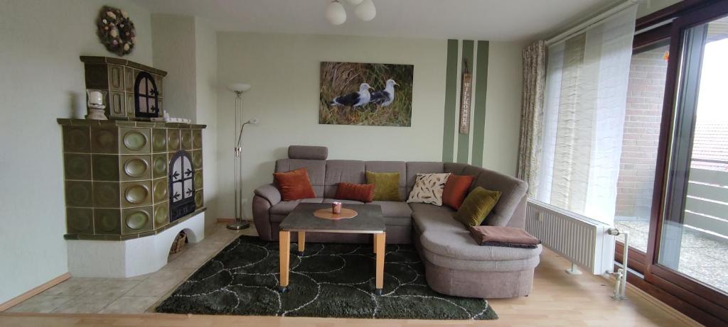a living room with a couch and a table at Grüne Düne Meerblick in Friedrichskoog-Spitz