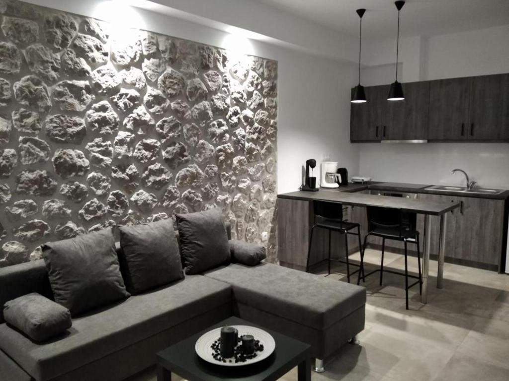 a living room with a couch and a kitchen at Armonia - Brand new apartment in Ermioni Village in Ermioni