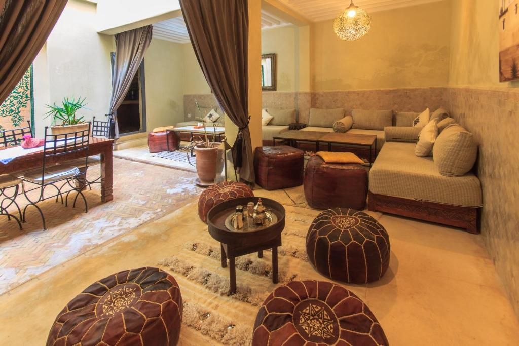 Riad La Porte de l'oasis في مراكش: غرفة معيشة مع أريكة وطاولة