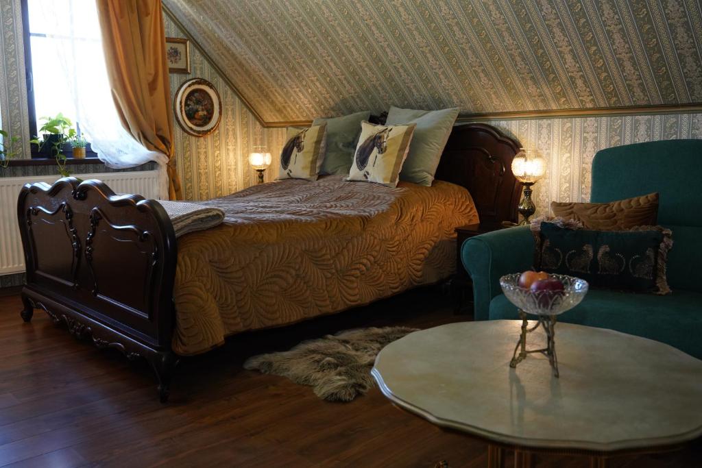 a bedroom with a bed and a table and a couch at Królowa Luiza i Wiking in Stare Jabłonki