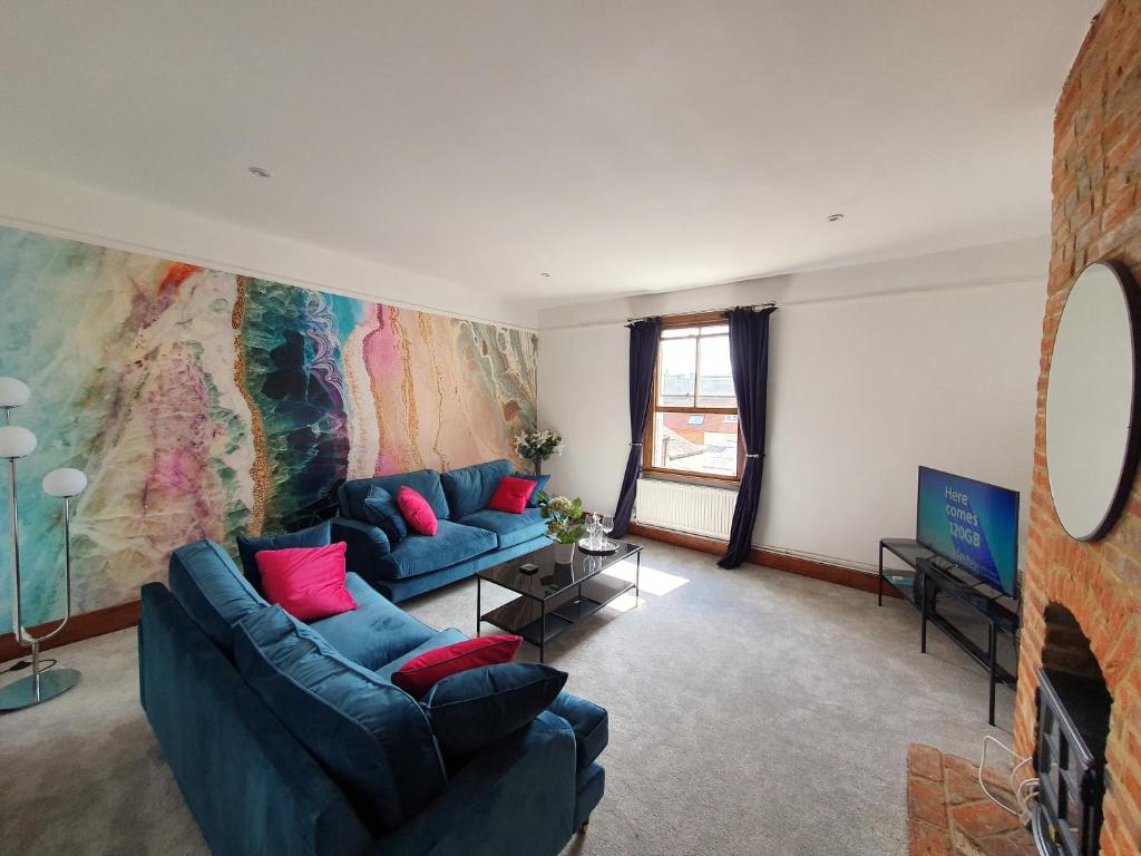 a living room with two blue couches and a tv at Stylish City Centre Apartment on the Kings Mile in Canterbury