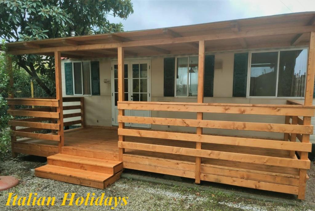 a screened in porch with a wooden fence at Italian Holidays Mobile house in Ameglia in Ameglia