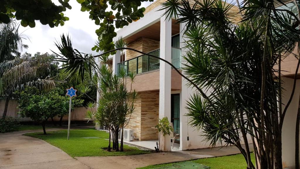 ein Gebäude mit Palmen davor in der Unterkunft Apartamento flat - Iloa Residence 1 in Barra de São Miguel