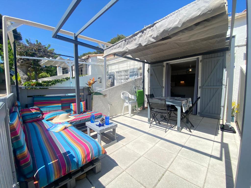 Elle comprend un balcon avec un lit et une table sur la terrasse. dans l'établissement La Maison Bleue, à Gruissan