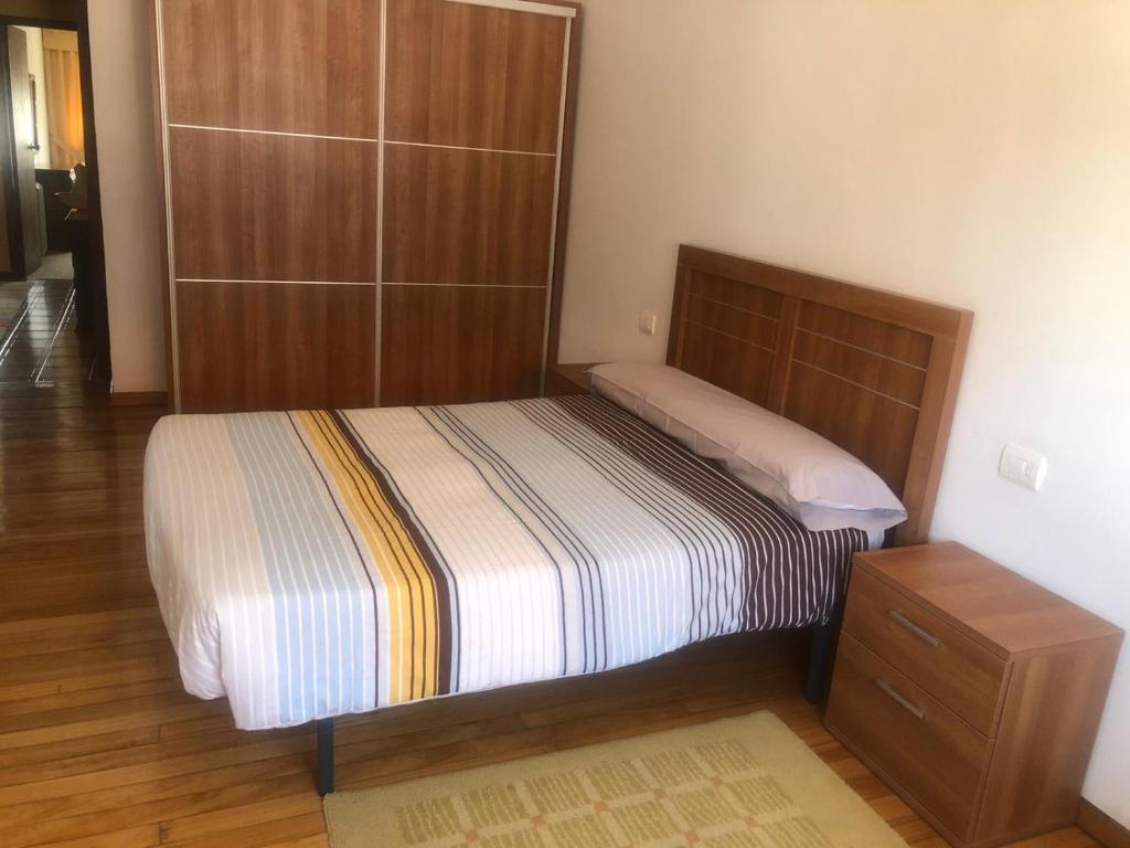 um quarto com uma cama e um armário de madeira em S lazaro em Noya