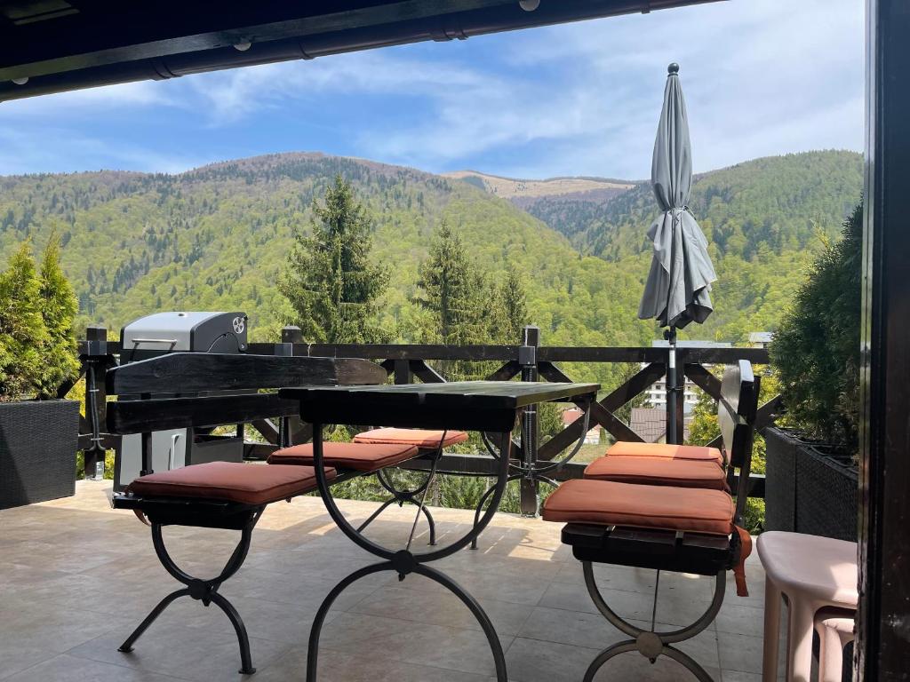 a patio with a table and chairs and an umbrella at The Nest in Sinaia