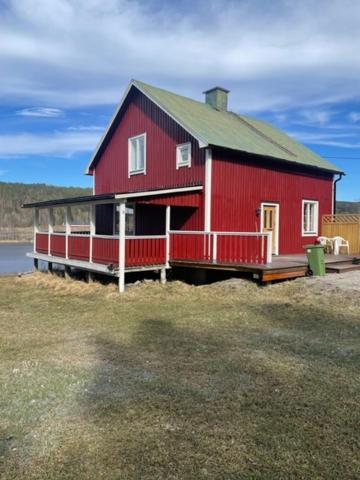 a red barn sitting on top of a field at Stavred-gården in Bjärtrå